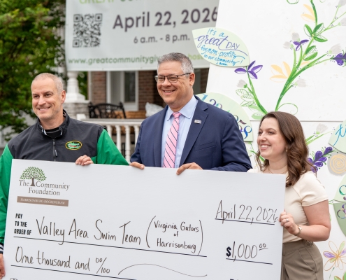 a group of people hold an oversized check
