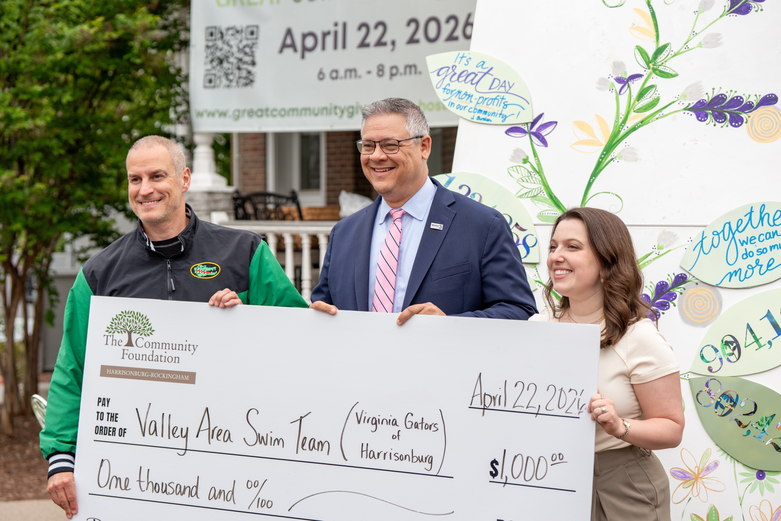 a group of people hold an oversized check